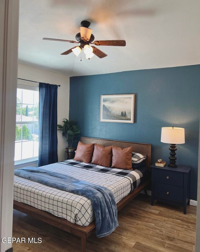 bedroom with wood-type flooring and ceiling fan