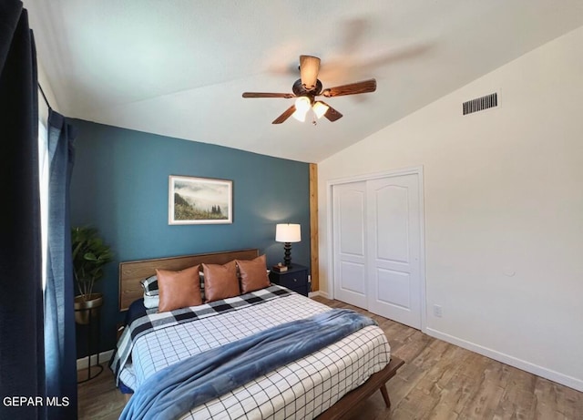 bedroom featuring a closet, ceiling fan, hardwood / wood-style flooring, and vaulted ceiling