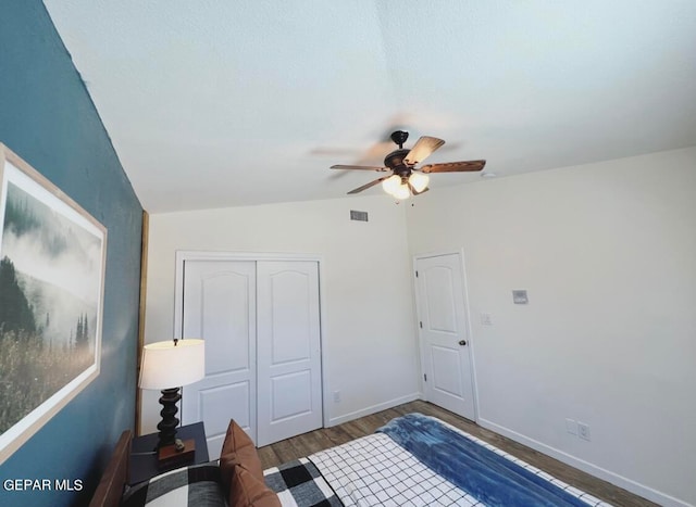 bedroom featuring vaulted ceiling, dark hardwood / wood-style floors, a closet, and ceiling fan