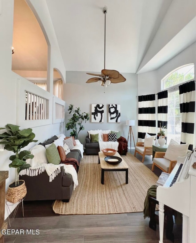 living room with dark hardwood / wood-style floors, ceiling fan, and vaulted ceiling