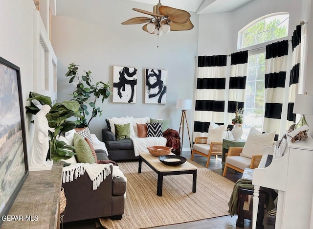 living room featuring ceiling fan and a high ceiling