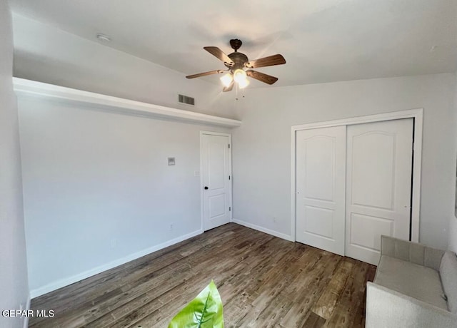 unfurnished bedroom featuring a closet, ceiling fan, lofted ceiling, and dark hardwood / wood-style flooring