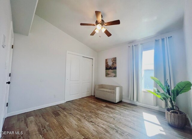 unfurnished bedroom featuring a closet, ceiling fan, hardwood / wood-style flooring, and vaulted ceiling