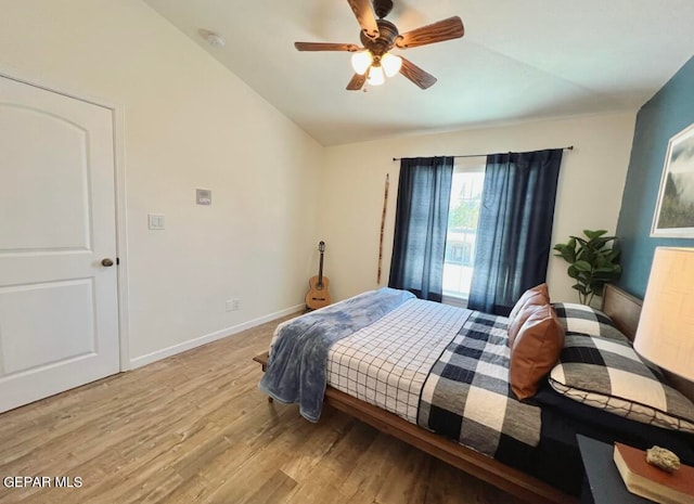 bedroom featuring light hardwood / wood-style floors, lofted ceiling, and ceiling fan