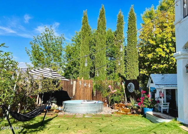 view of yard featuring a hot tub and a storage unit