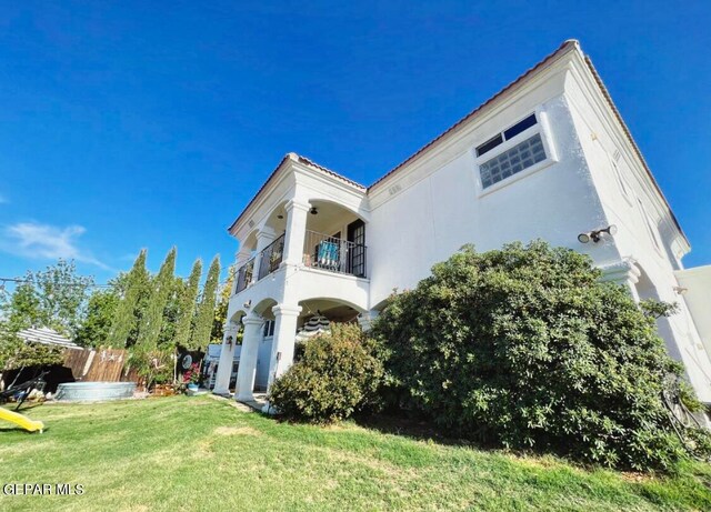 view of front of property with a balcony and a front yard