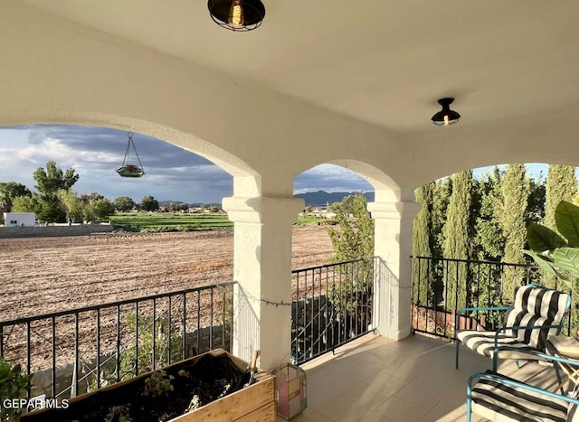 view of patio / terrace with a balcony and a rural view