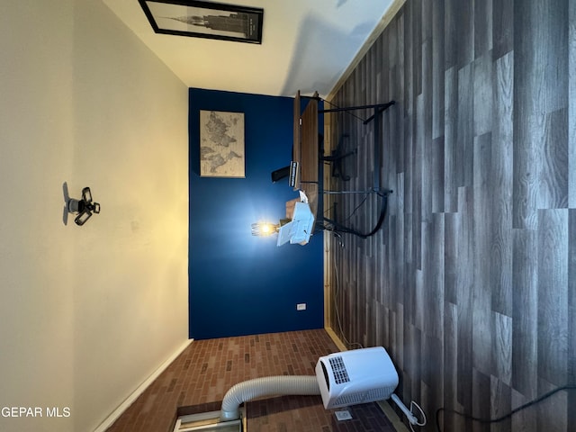 interior space with vaulted ceiling and wood walls