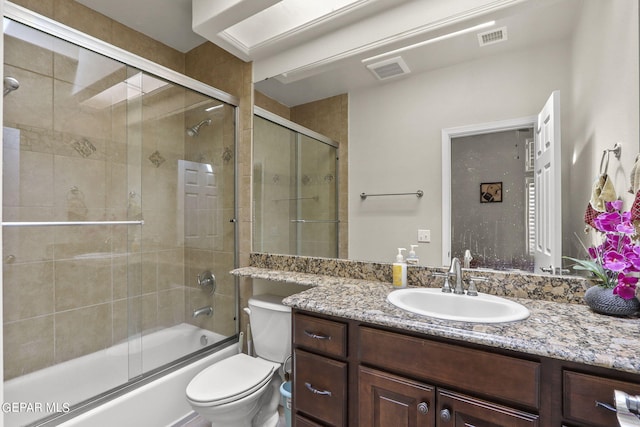 full bathroom with vanity, toilet, and enclosed tub / shower combo