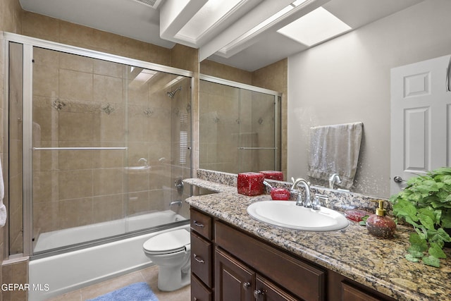 full bathroom with tile patterned floors, combined bath / shower with glass door, toilet, and vanity