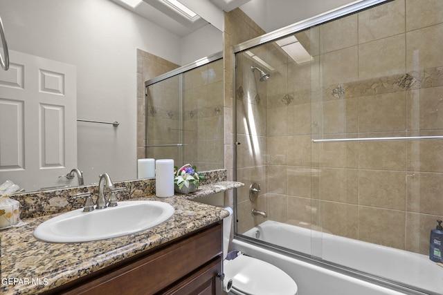 full bathroom with vanity, toilet, and enclosed tub / shower combo