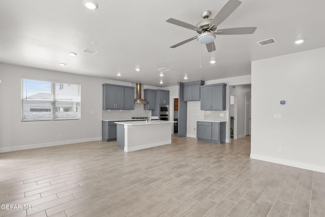 kitchen featuring gray cabinets, light hardwood / wood-style flooring, and wall chimney range hood