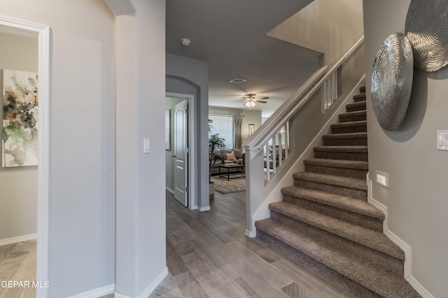 stairway featuring hardwood / wood-style floors and ceiling fan