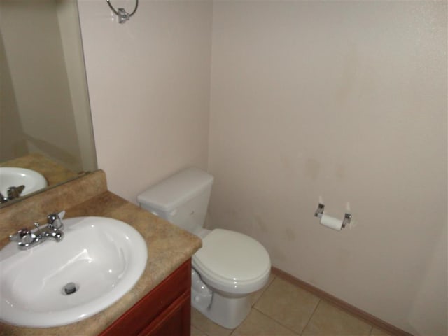 bathroom with toilet, vanity, and tile patterned flooring