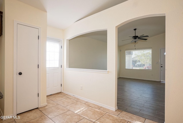 unfurnished room with light tile patterned flooring, vaulted ceiling, and ceiling fan