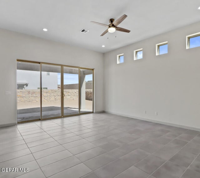 tiled spare room featuring ceiling fan