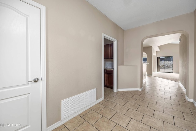 hall featuring light tile patterned floors