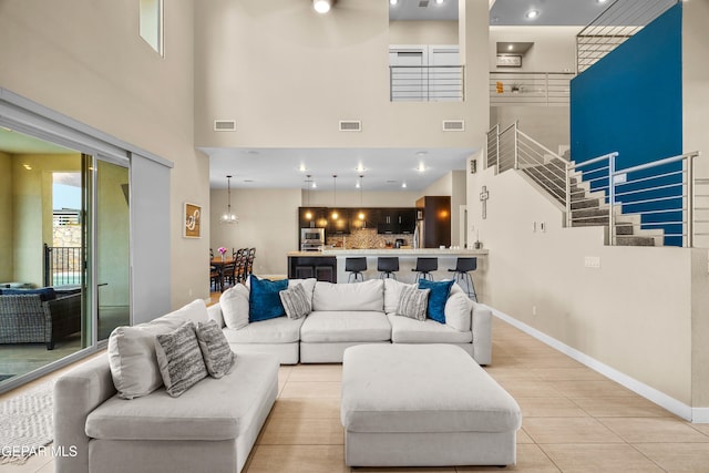 tiled living room featuring a towering ceiling