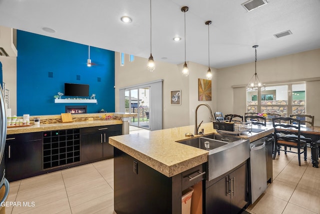 kitchen featuring dishwasher, pendant lighting, a center island with sink, and sink