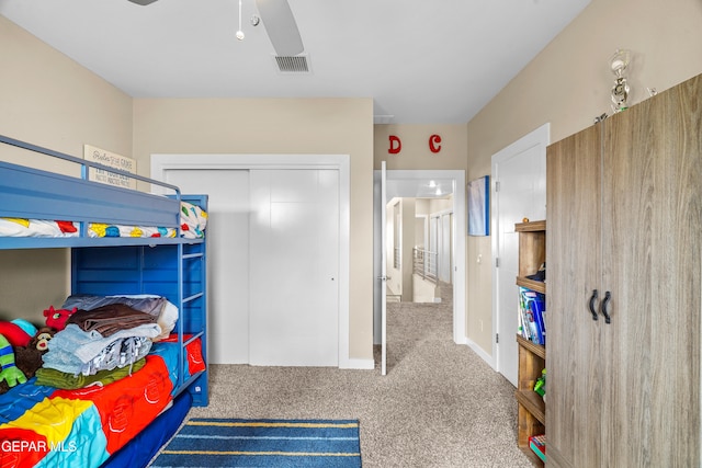 carpeted bedroom featuring ceiling fan and a closet