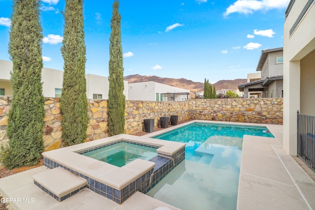 view of pool with a mountain view and an in ground hot tub