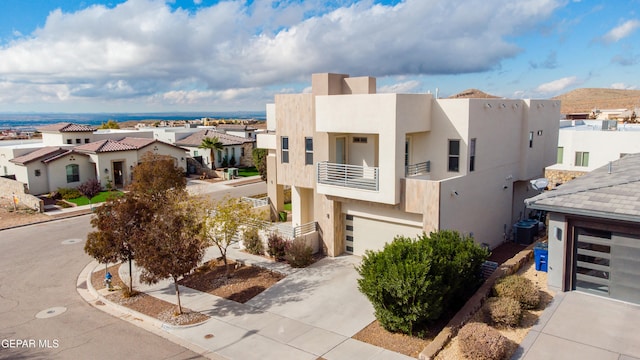 view of front of home featuring central air condition unit, a balcony, and a garage