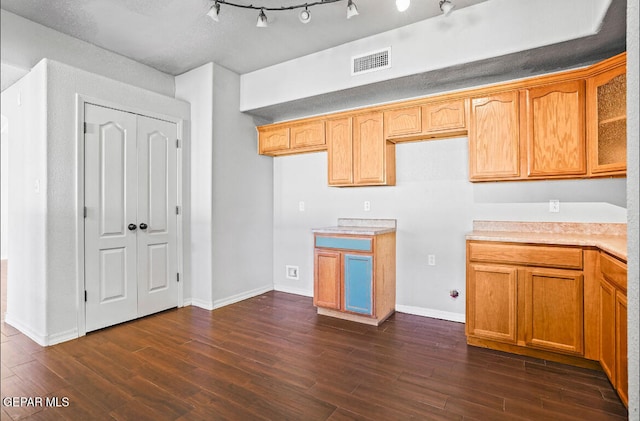 kitchen with dark wood-type flooring, a textured ceiling, and rail lighting