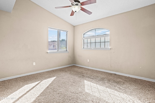 carpeted spare room with a textured ceiling, ceiling fan, and vaulted ceiling