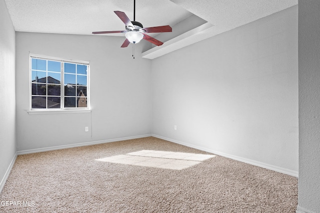 carpeted spare room with vaulted ceiling, ceiling fan, and a textured ceiling