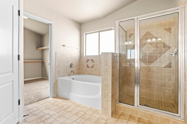 bathroom featuring separate shower and tub, tile patterned floors, and vaulted ceiling