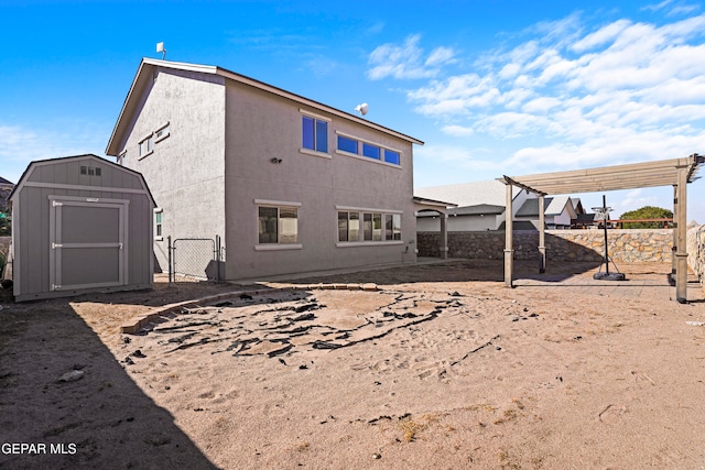 rear view of house with a pergola and a shed