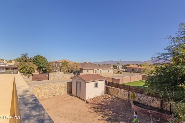 view of yard featuring a mountain view and a storage shed