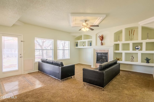 living room featuring built in shelves, ceiling fan, and a textured ceiling