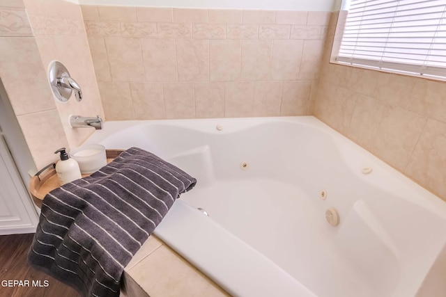 bathroom featuring hardwood / wood-style floors and a tub to relax in