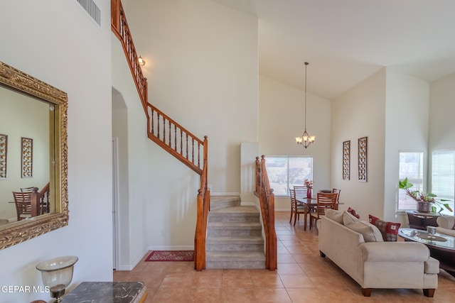 stairway with high vaulted ceiling, tile patterned flooring, and a chandelier