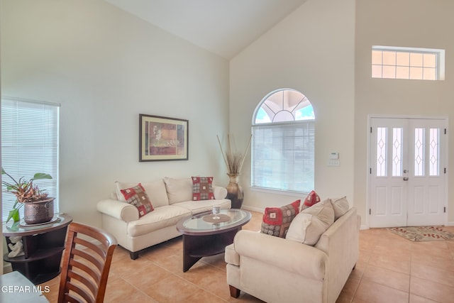 living room featuring high vaulted ceiling, plenty of natural light, and light tile patterned flooring