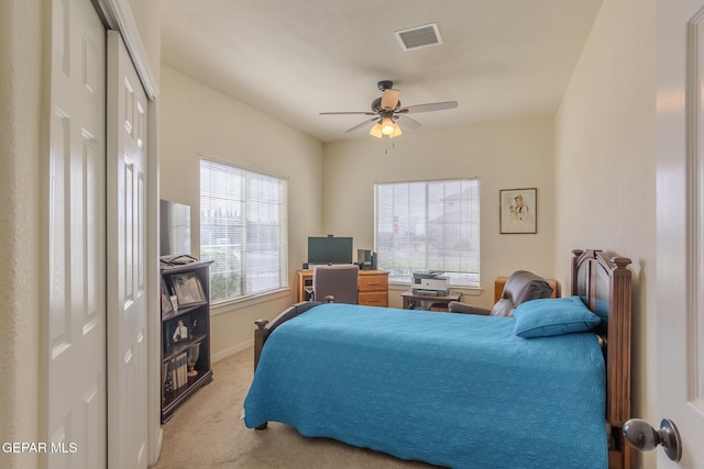 bedroom featuring light carpet, ceiling fan, and a closet