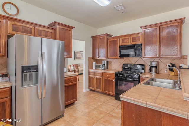 kitchen featuring black appliances, sink, tasteful backsplash, and light tile patterned flooring