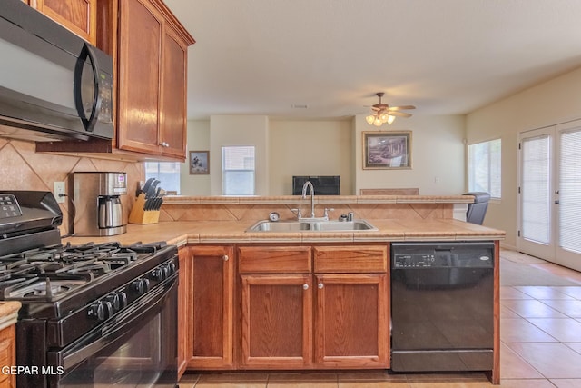 kitchen featuring decorative backsplash, black appliances, sink, light tile patterned floors, and ceiling fan