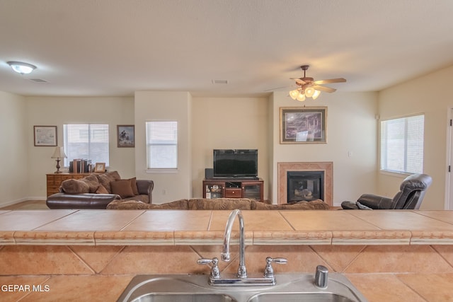 kitchen with tile counters, a healthy amount of sunlight, and sink