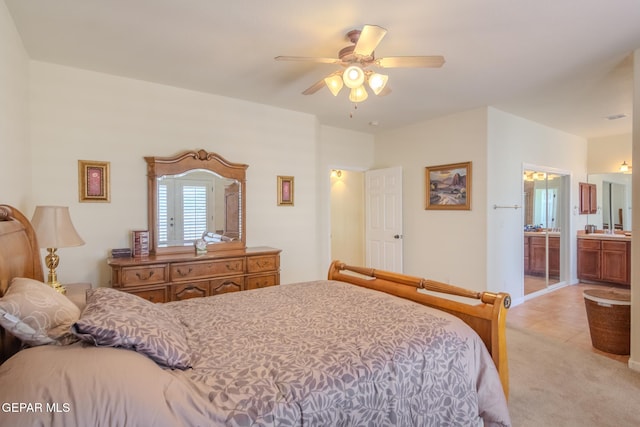 carpeted bedroom with ceiling fan and ensuite bath