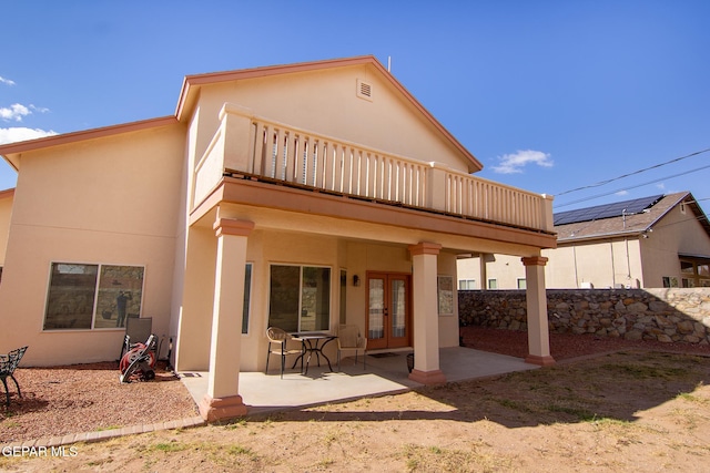 rear view of house featuring a balcony and a patio area