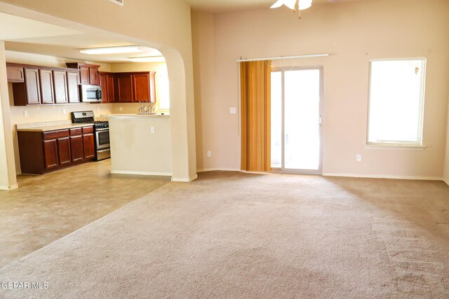 unfurnished living room with light carpet and ceiling fan