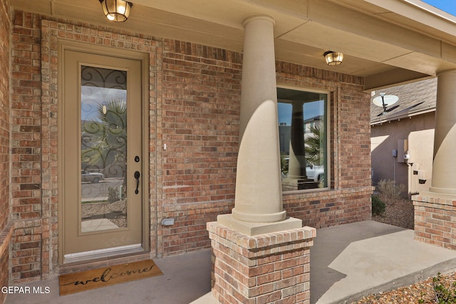 view of exterior entry featuring covered porch