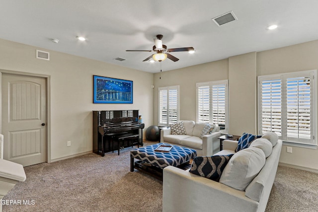 carpeted living room with ceiling fan