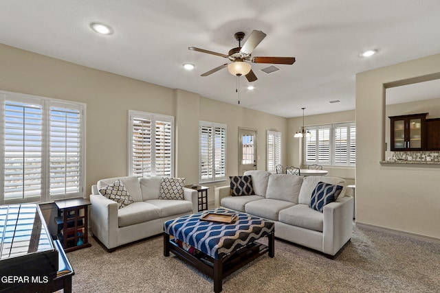 living room featuring ceiling fan and carpet