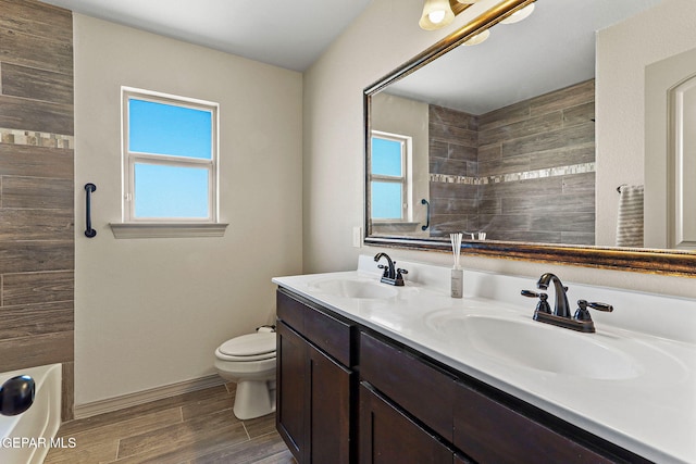 full bathroom with vanity, toilet, a healthy amount of sunlight, and bathing tub / shower combination