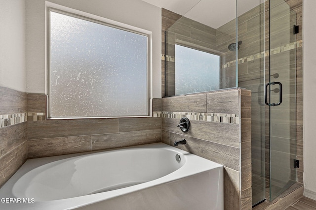 bathroom featuring shower with separate bathtub