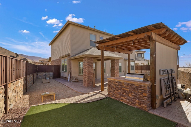 back of house featuring exterior kitchen, a patio area, and a pergola