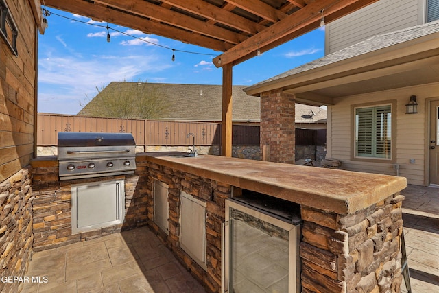 view of patio with sink, an outdoor kitchen, and area for grilling